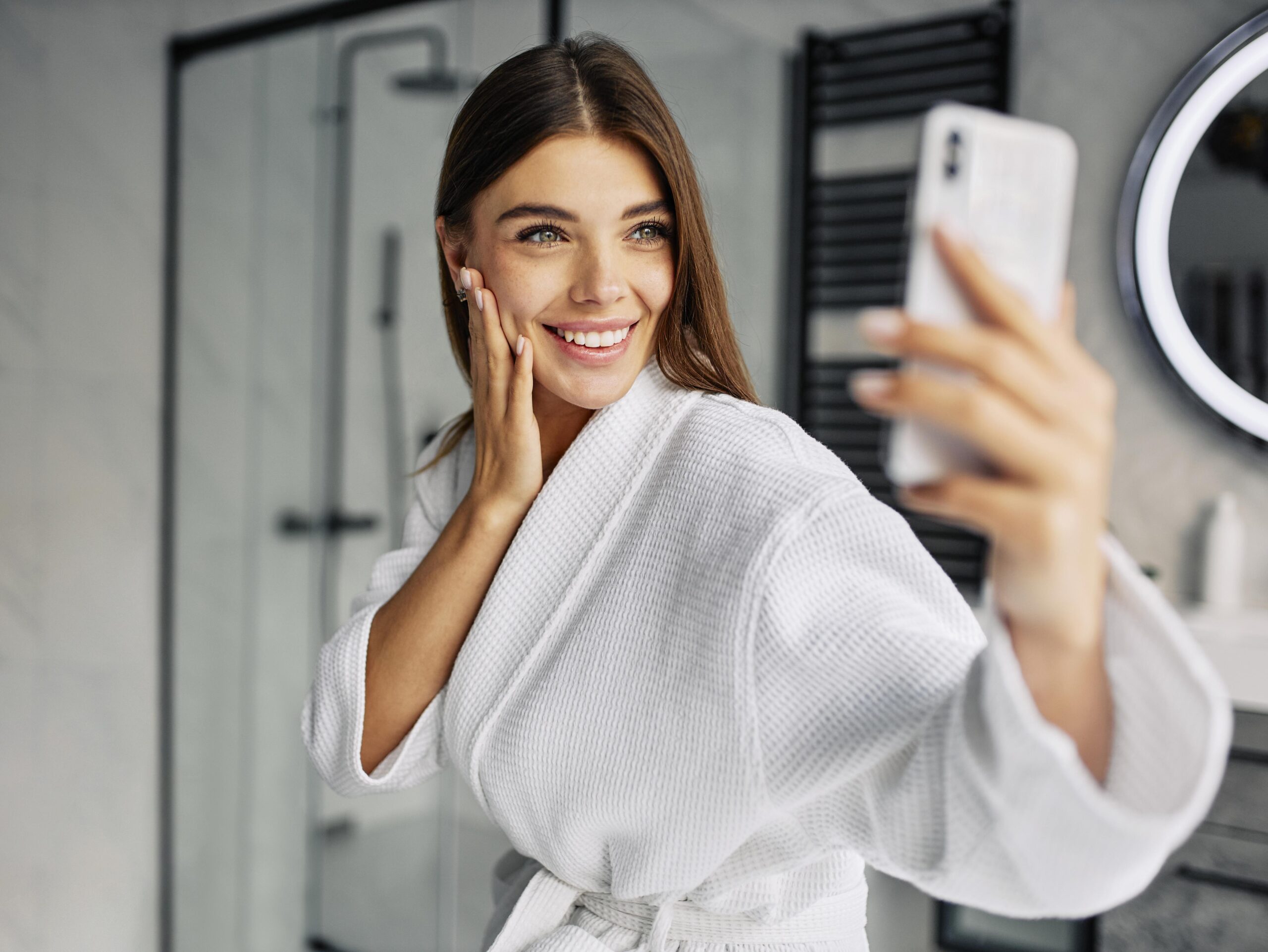 Woman Smiling taking a selfie in a bathrobe